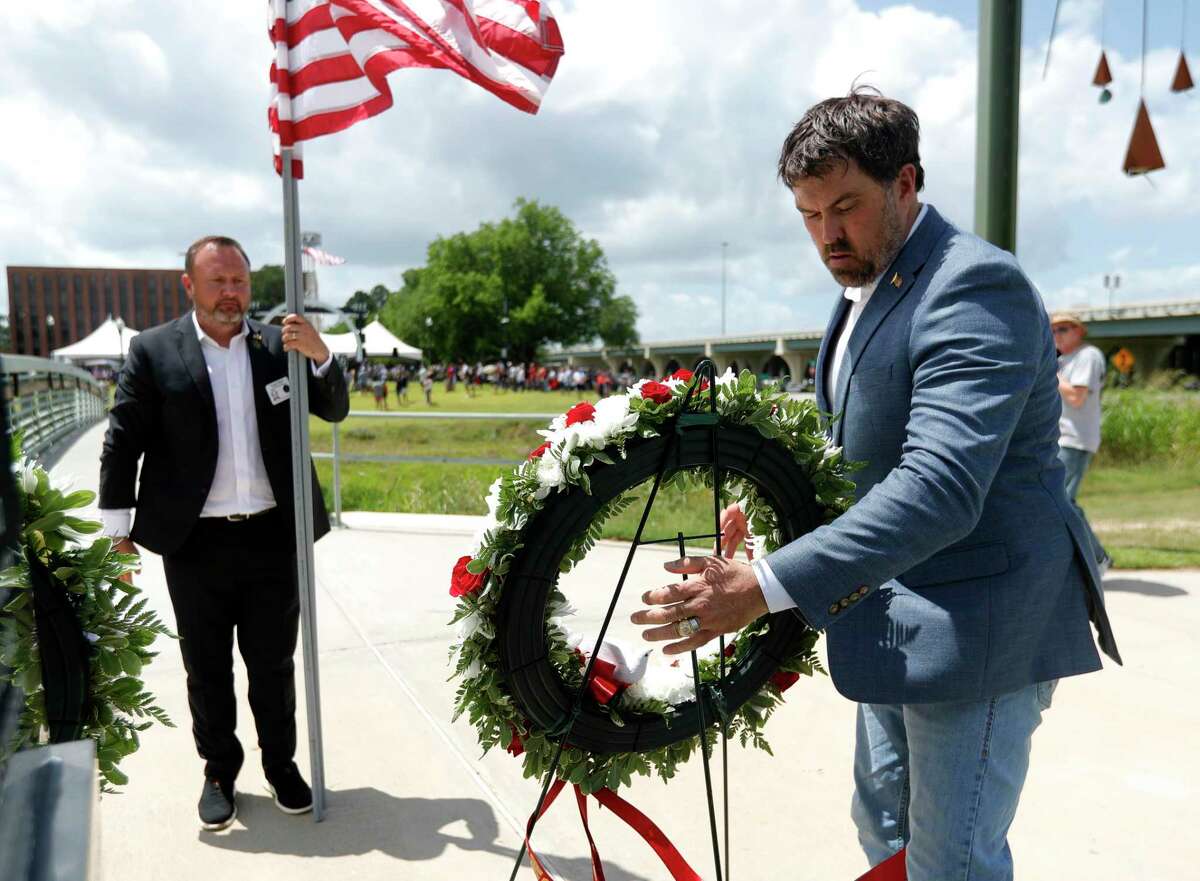 Navy veteran Morgan Luttrell, right, places a wreath in front of Conroe City Councilman Howard Wood during a Memorial Day celebration at the Montgomery County Veterans Memorial Park, Monday, May 30, 2022, in Conroe.