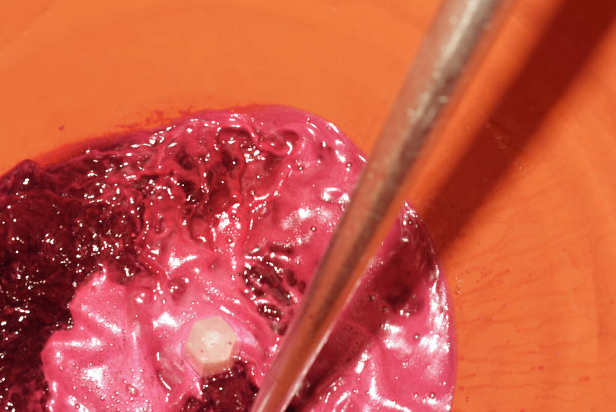 A rose quartz crystal sits at the bottom of a clay amphora, which is being filled with a wine made with a blend of Frontenac and St. Croix varieties for Ardure Wines.