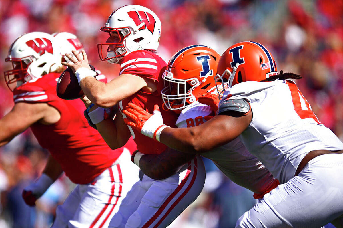 Wisconsin quarterback Graham Mertz (5) is sacked by Illinois defensive lineman Keith Randolph Jr. (88) and teammate Jer'Zhan Newton (4) during the second half of an NCAA college football game Saturday, Oct. 1, 2022, in Madison, Wis. 