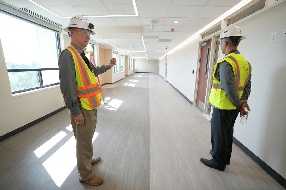 Kent Hudson, facilities manager, left, shows Dr. Esmaeil Porsa, president and CEO for Harris Health System, right, the waiting area for the Thomas Street Health Center at Harris Health System’s Quentin Mease facility, which is under construction Wednesday, Oct. 5, 2022, in Houston.