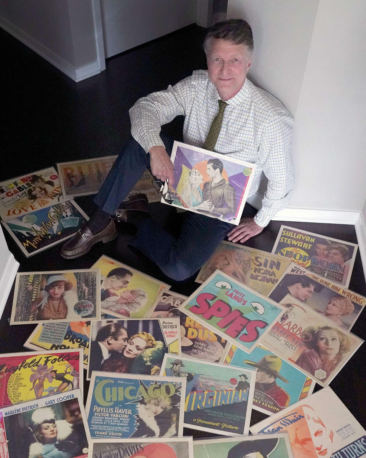 Collector Dwight Cleveland holds the first lobby cards he collected, for the movie "Wolf Song."