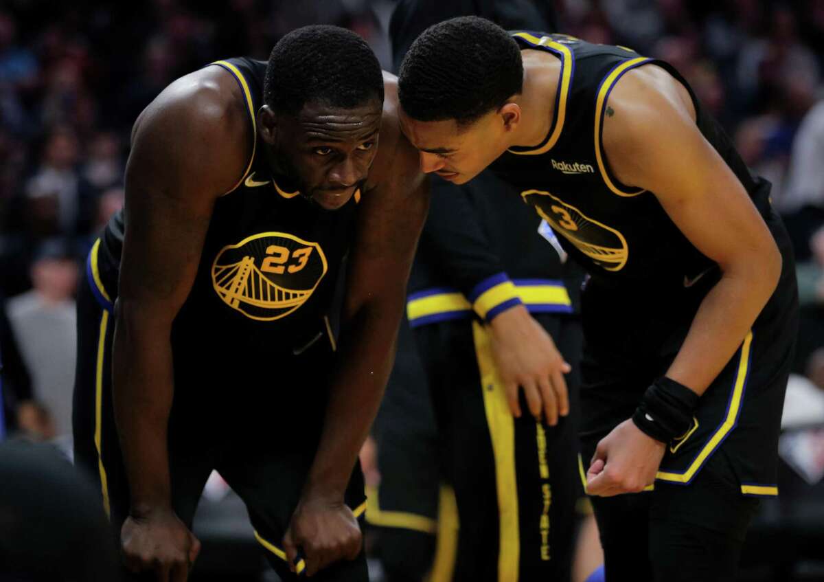 Jordan Poole (3) checks on Draymond Green (3) who was banged up on a foul going for a layup as the Golden State Warriors played the Phoenix Suns at Chase Center in San Francisco, Calif., on Wednesday, March 30, 2022.