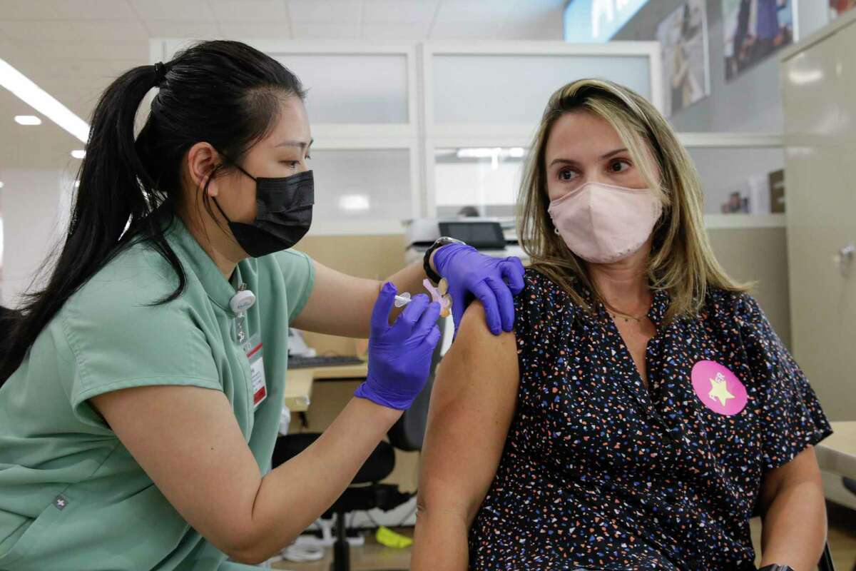 Nurse Marilyn Antonio gives a Pfizer booster shot to Mariana Black in September at the Kaiser Permanente City Center Vaccine Clinic in San Francisco. As vaccination rates decline, preventable diseases are making an unwelcome comeback.