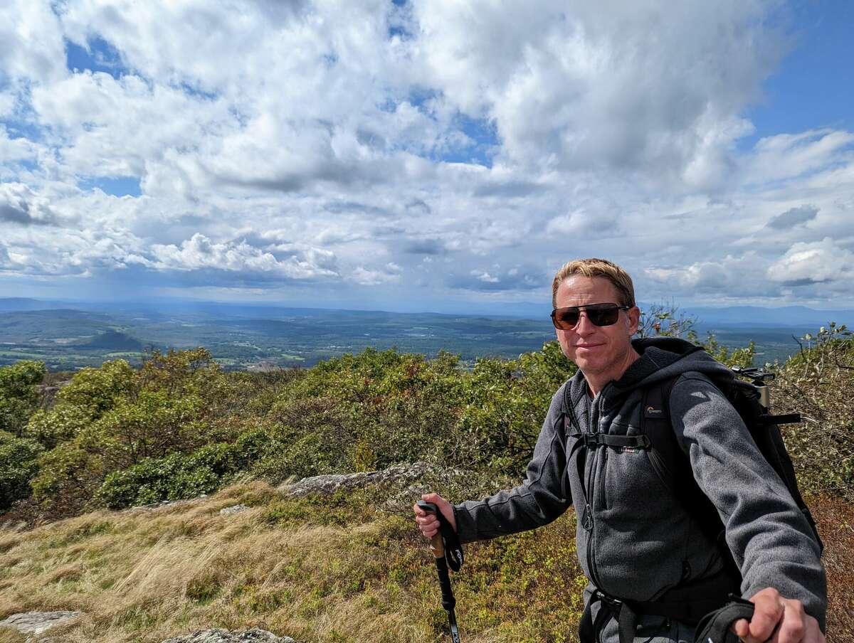 Mark Lotterhand poses at the top of a mountain on a snake-finding hike with CT Insider early autumn 2022. 