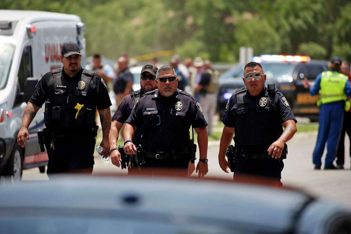 FILE — Police walk near Robb Elementary School following a shooting, May 24, 2022, in Uvalde, Texas. Four months after the Robb Elementary School shooting, the Uvalde school district on Friday, Oct. 7 pulled its entire embattled campus police force off the job following a wave of new outrage over the hiring of a former Texas state trooper who was part of the hesitant law enforcement response as a gunman killed 19 children and two teachers.