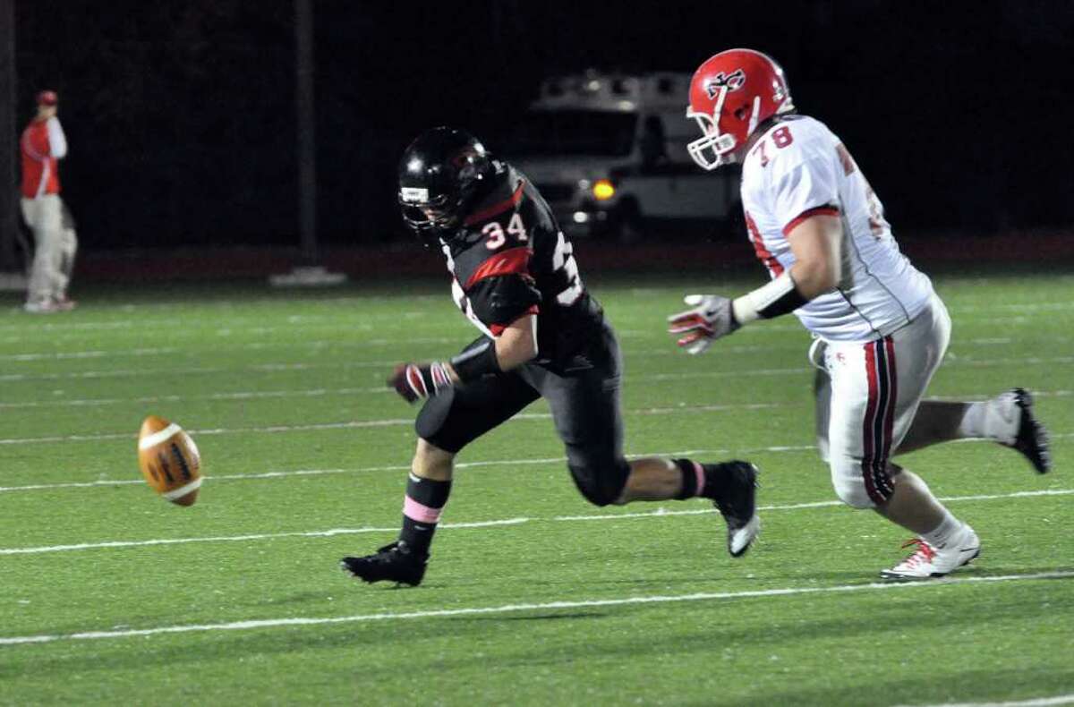 Fairfield Warde's David Wolff and New Canaan's Conor Hanratty chase after a fumbled ball during the football game at Warde on Friday, Oct. 8, 2010.