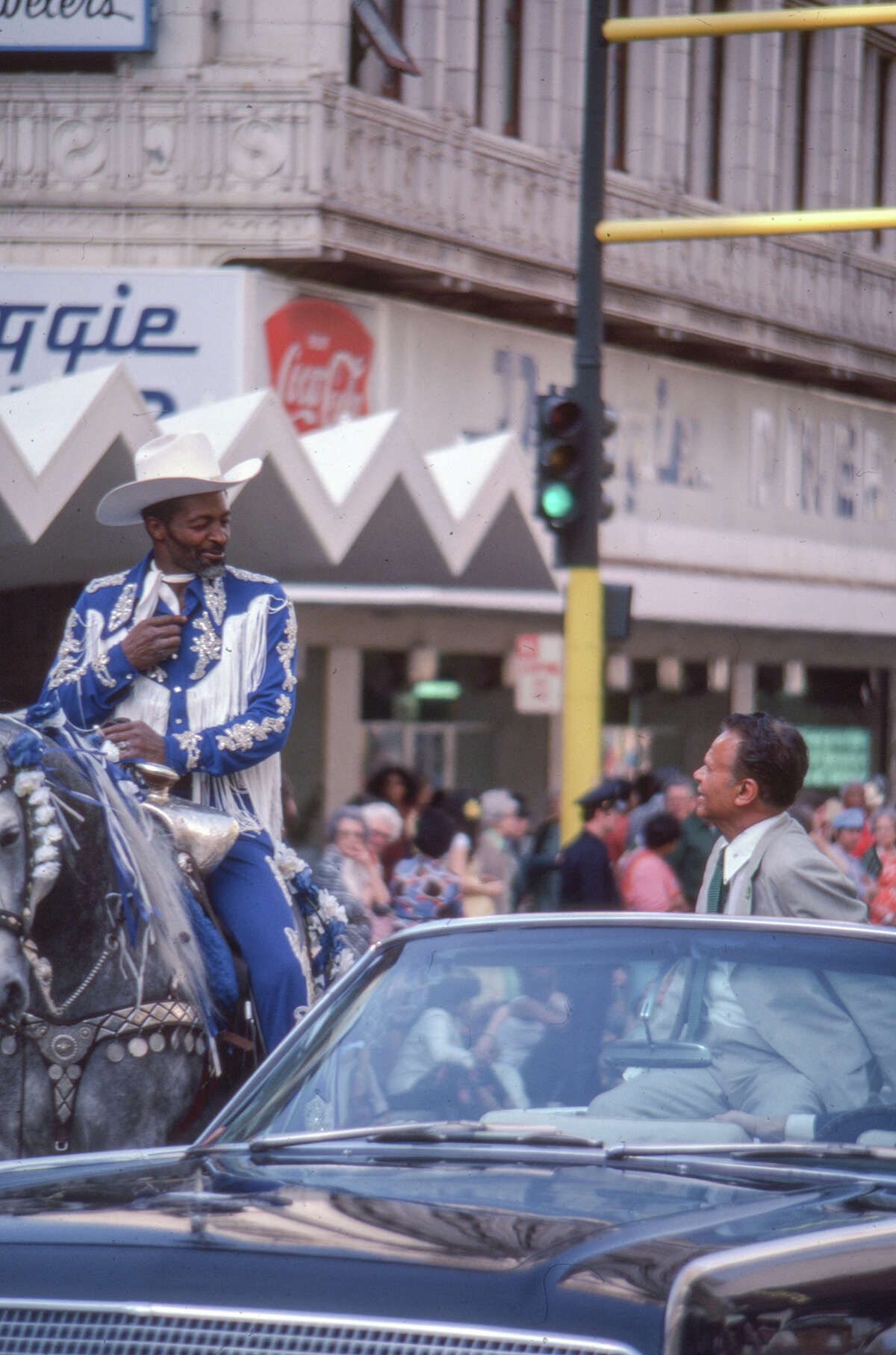 Former Oakland Mayor Lionel Wilson chats with a black cowboy on horseback in front of what was once the Dougie Diner on Broadway in Oakland. Date unknown. 