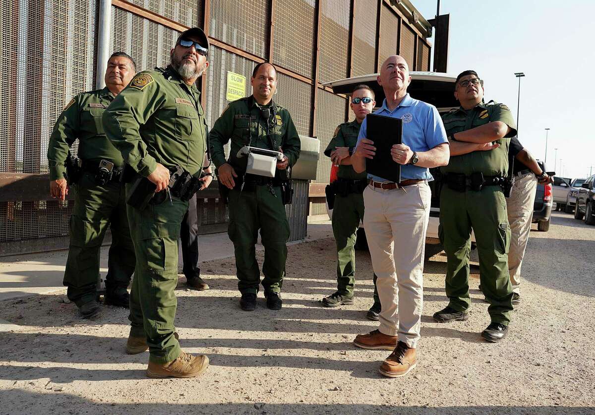 Homeland Security Secretary Alejandro Mayorkas, second from right, looks up along with U.S Border Patrol agents as a drone flies overhead as he tours a section of the border wall May 17, 2022, in Hidalgo.