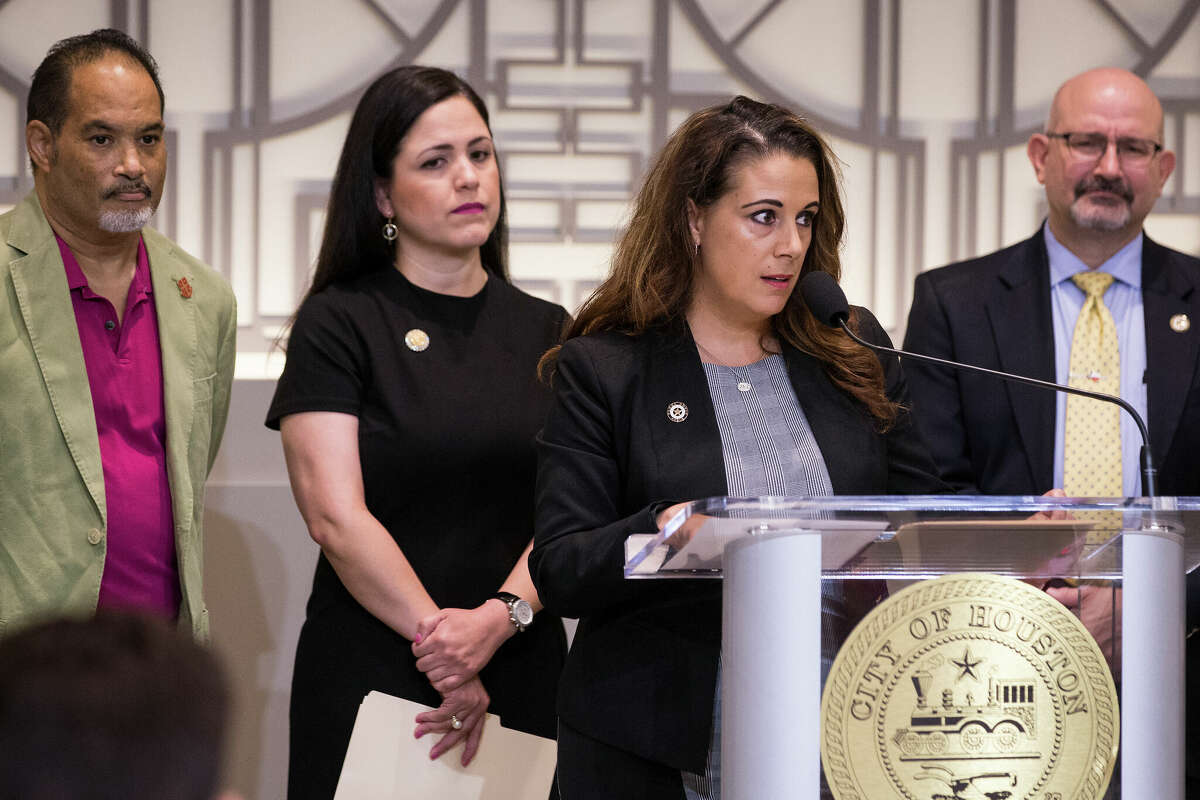 Rep. Gina Calanni, at the podium, and Rep. Jon Rosenthal, far right, stand with other members of the Texas House Democratic Caucus, during a news conference to demand Gov. Greg Abbott to call a special session aimed at limiting gun violence on Wednesday, Sept. 4, 2019, in Houston.