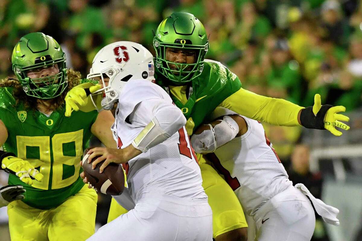 Oregon defensive end Brandon Dorlus (3) sacks Stanford quarterback Tanner McKee (18) as defensive lineman Casey Rogers (98) comes in on the play during the second half of an NCAA college football game Saturday, Oct. 1, 2022, in Eugene, Ore. (AP Photo/Andy Nelson)