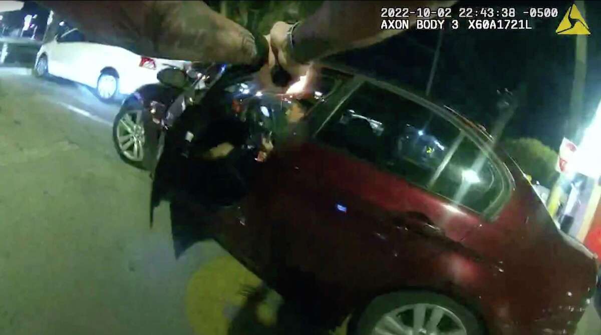 In this image taken from Oct. 2, 2022 police body camera video and released by San Antonio Police Department, San Antonio Police officer James Brennand shoots Erik Cantu, who was holding a hamburger in a fast food restaurant parking lot, as Cantu drives away in San Antonio, Texas. Brennand opened fire several times wounding the unarmed teenager as he drove away. Brennand was fired after the shooting, police training commander Alyssa Campos said in a video statement released Wednesday, Oct. 5, 2022. (San Antonio Police Department via AP)