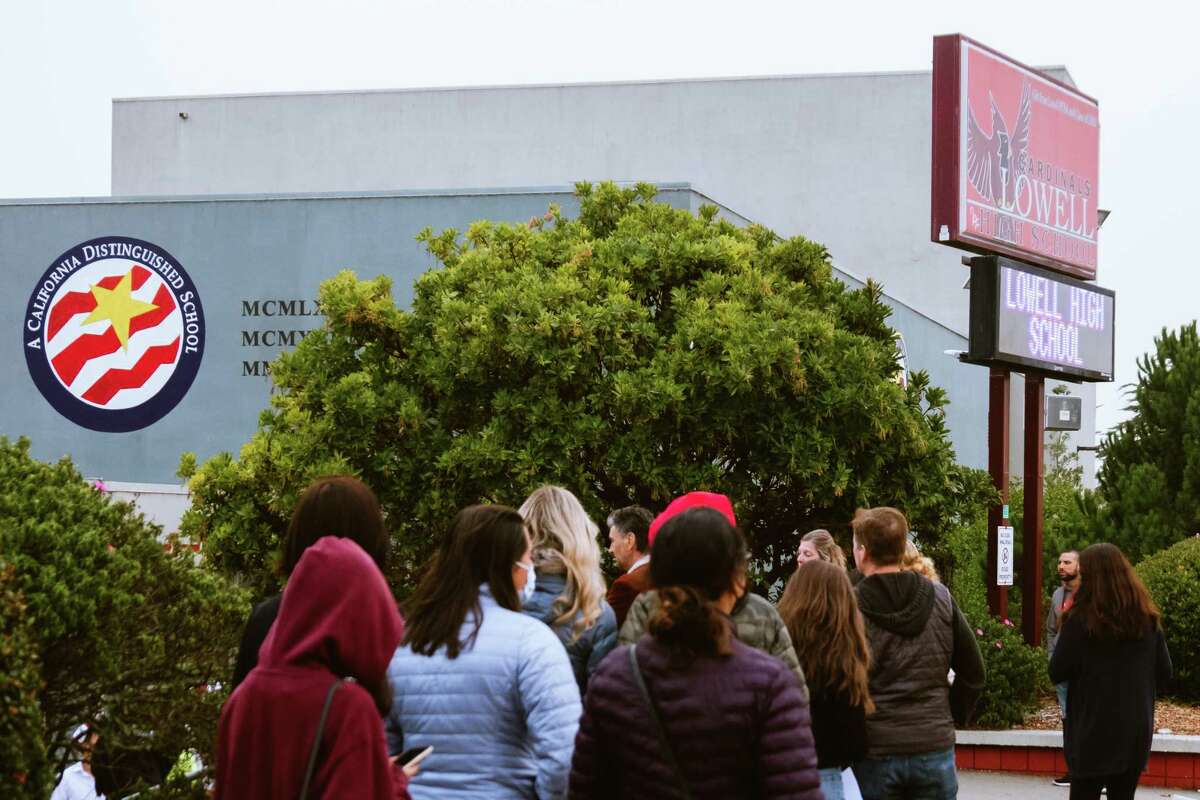 Parents line up with their children at Lowell High School in San Francisco in October during an open house as it prepares to switch back to a merit-based admission process.