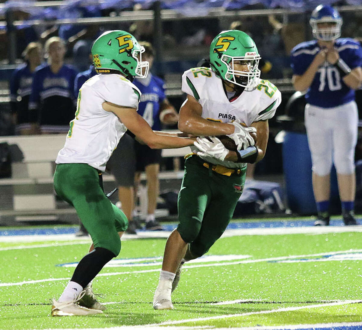 Southwestern's Jacob Fisher (right) takes a handoff from QB Quinten Strohbeck in a Week 6 game at Carlinville. On Friday night, Fisher rushed for a career-high 133 yards in the Piasa Birds' SCC victory over Vandalia at Knapp Field in Piasa.