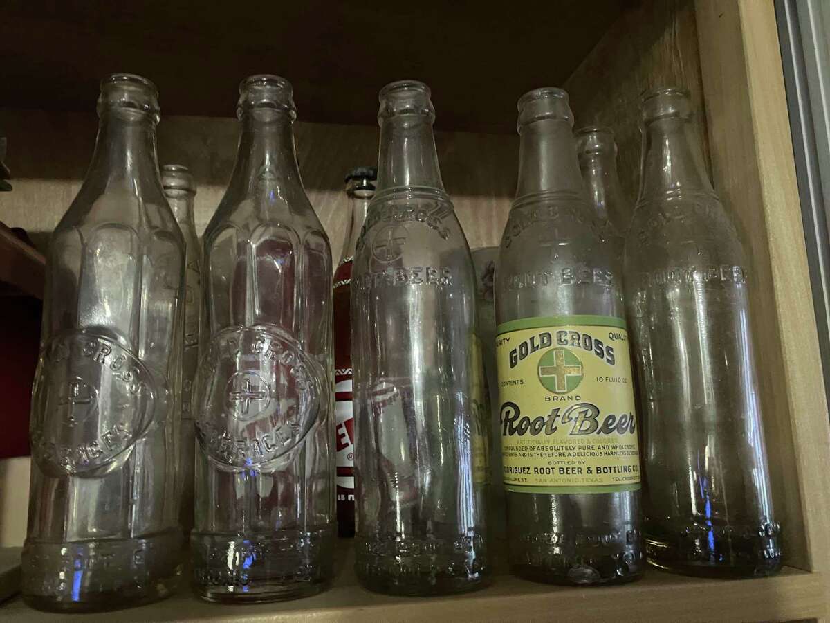 Gina Velasquez has kept some of the 1920s bottles from the family-owned bottling company started by her great-grandfather, Guadalupe Rodriguez Sr. The one with a label once contained Gold Cross Root Beer, a popular brand of the period.