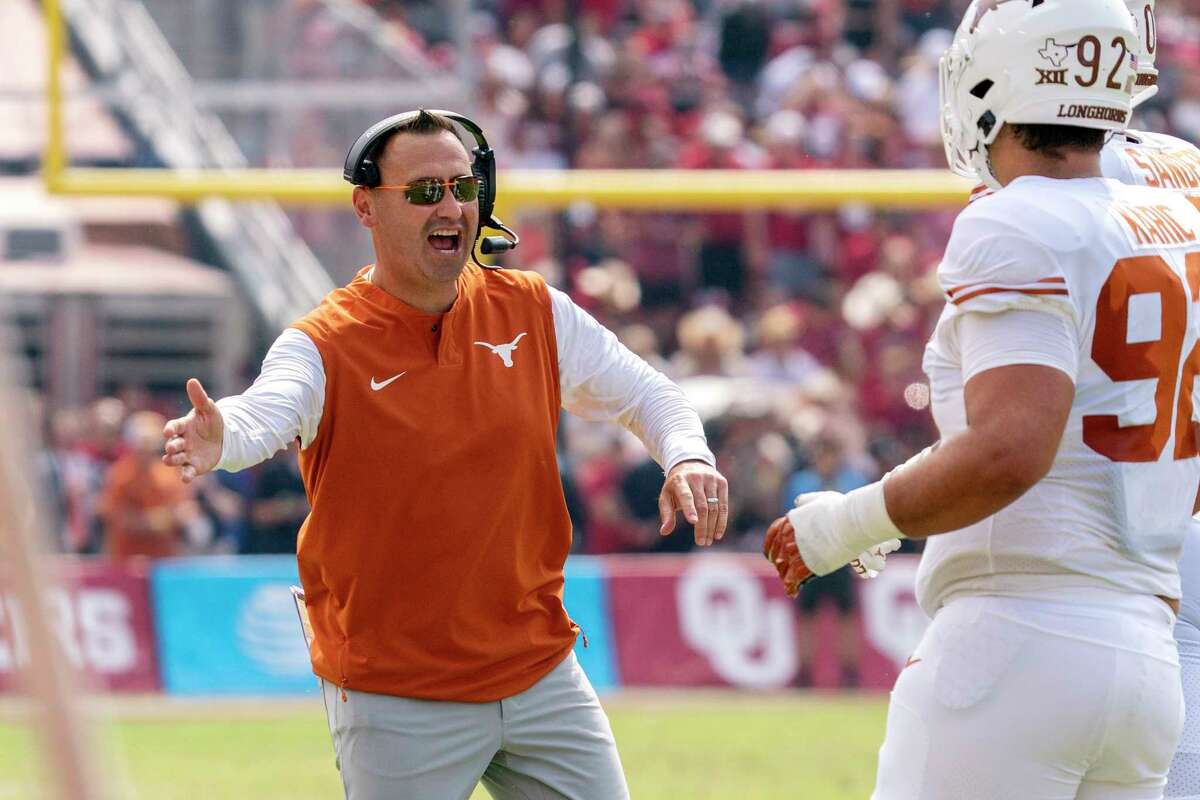 Texas head coach Steve Sarkisian congratulates players after a touchdown during the first half of an NCAA college football game against Oklahoma at the Cotton Bowl, Saturday, Oct. 8, 2022, in Dallas. (AP Photo/Jeffrey McWhorter)