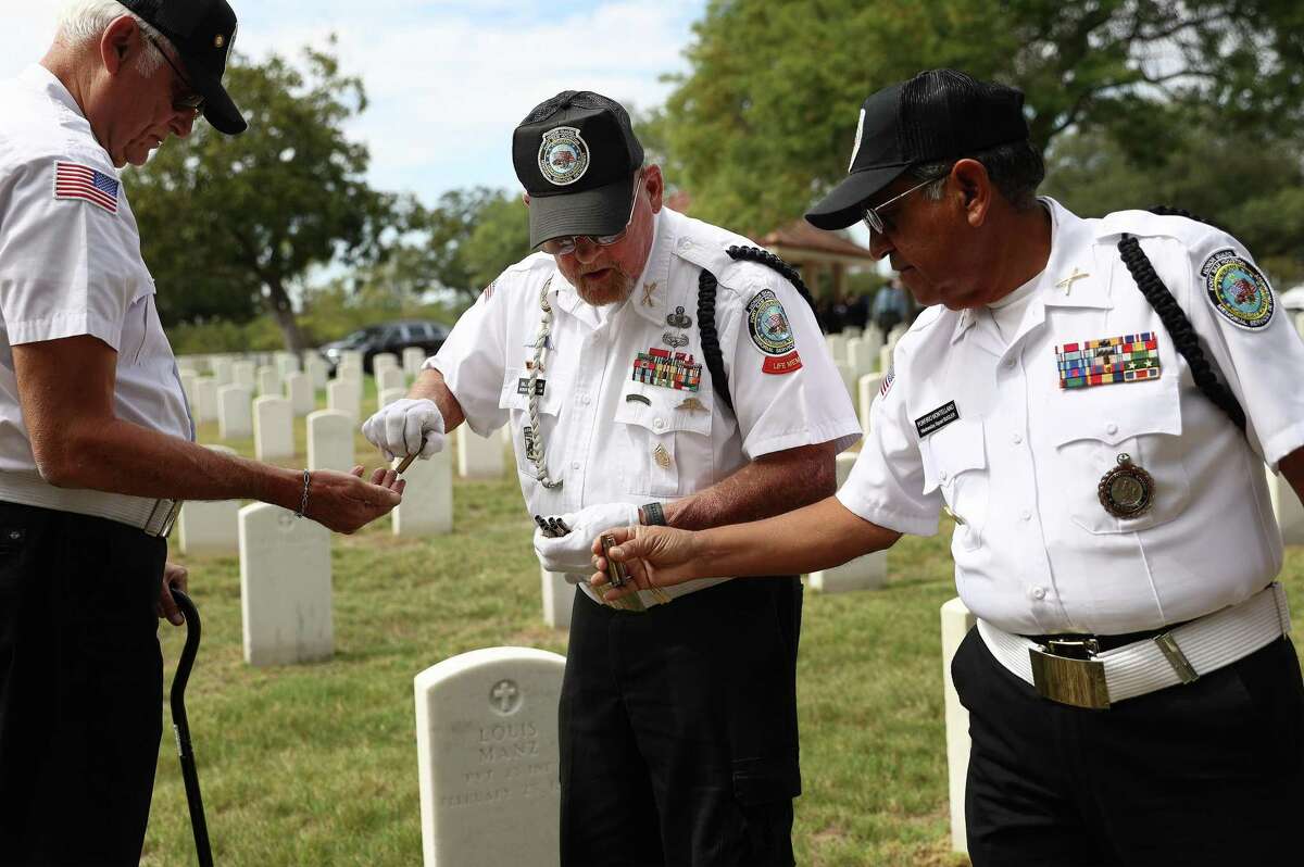 Retired Army Sgt. Maj. Bill Neuiszer (center) helps gather shell casings from the rifle volleys during a funeral service. The shell casings are given alongside a folded U.S. Flag to surviving family members. Neuiszer is one of the miliatary veterans who volunteer one day a week with the Memorial Services Detachment unit that provides full military burial honors at the Fort Sam Houston National Cemetery.