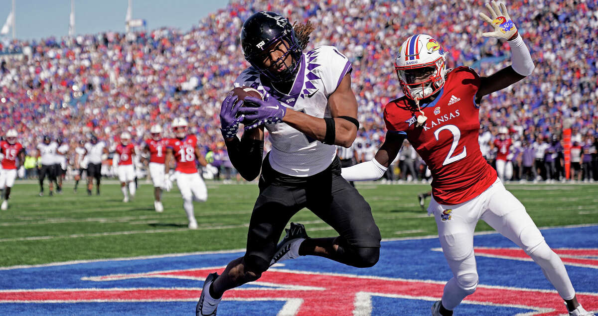 TCU wide receiver Quentin Johnston (1) catches the game-winning touchdown pass under pressure from Kansas cornerback Cobee Bryant during the second half of an NCAA college football game Saturday, Oct. 8, 2022, in Lawrence, Kan. TCU won 38-31. (AP Photo/Charlie Riedel)