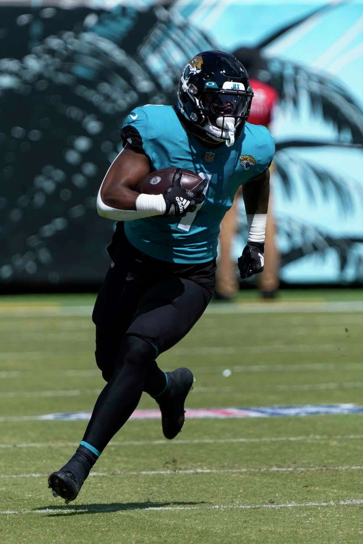 Jacksonville Jaguars running back Travis Etienne Jr. (1) runs the ball against the Houston Texans during the first half of an NFL football game in Jacksonville, Fla., Sunday, Oct. 9, 2022. (AP Photo/John Raoux)
