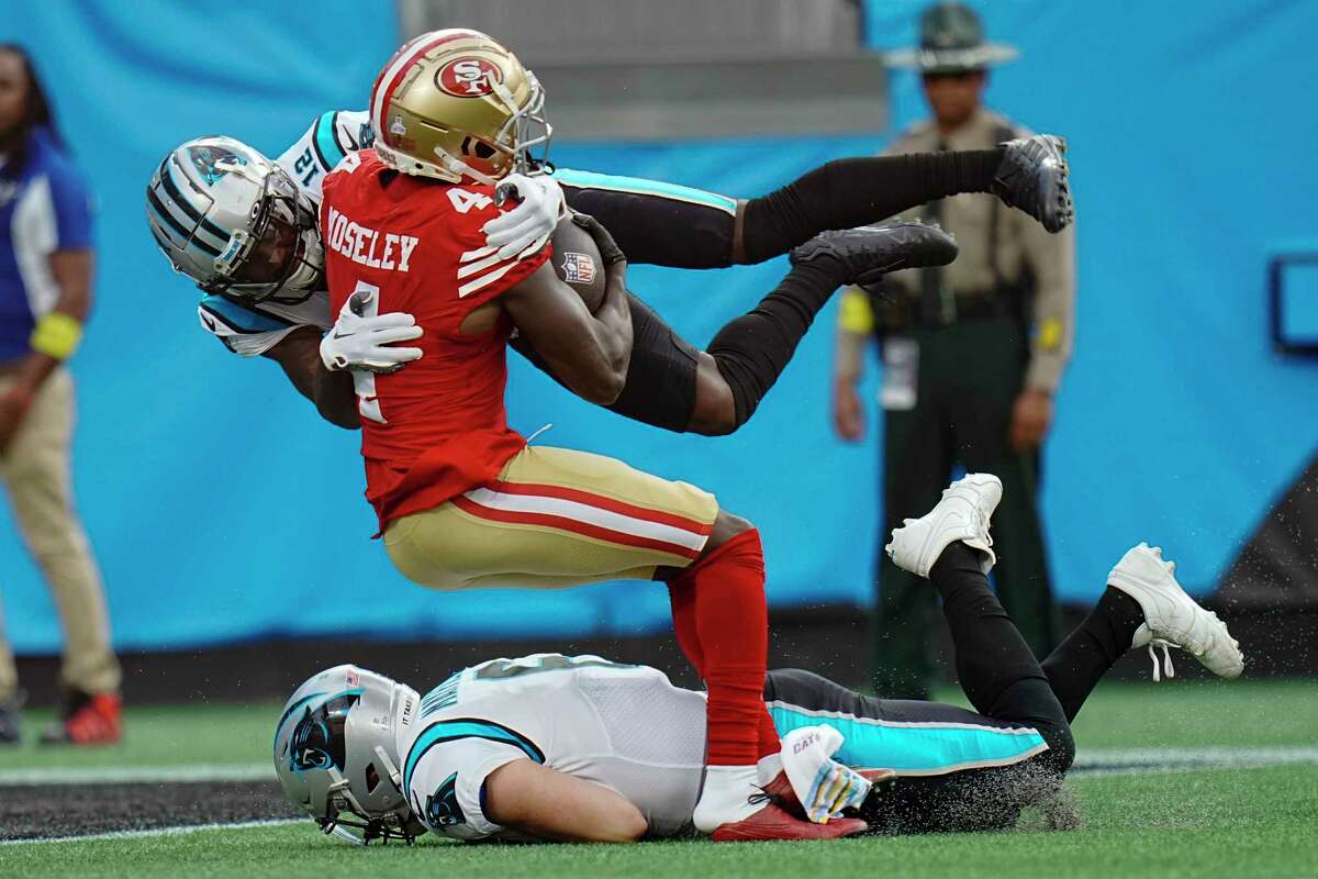 San Francisco 49ers cornerback Emmanuel Moseley scores between Carolina Panthers wide receiver Shi Smith and quarterback Baker Mayfield after an interception during the first half an NFL football game on Sunday, Oct. 9, 2022, in Charlotte, N.C. (AP Photo/Rusty Jones)