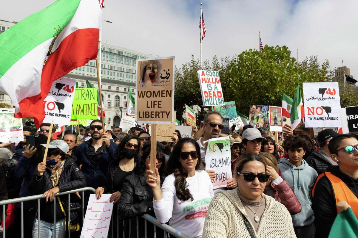 Demonstrators at Civic Center Plaza in San Francisco rally in support of the people of Iran protesting the death of a 22-year-old woman, who died last month in police custody after being arrested for allegedly violating the country’s strict dress code laws.