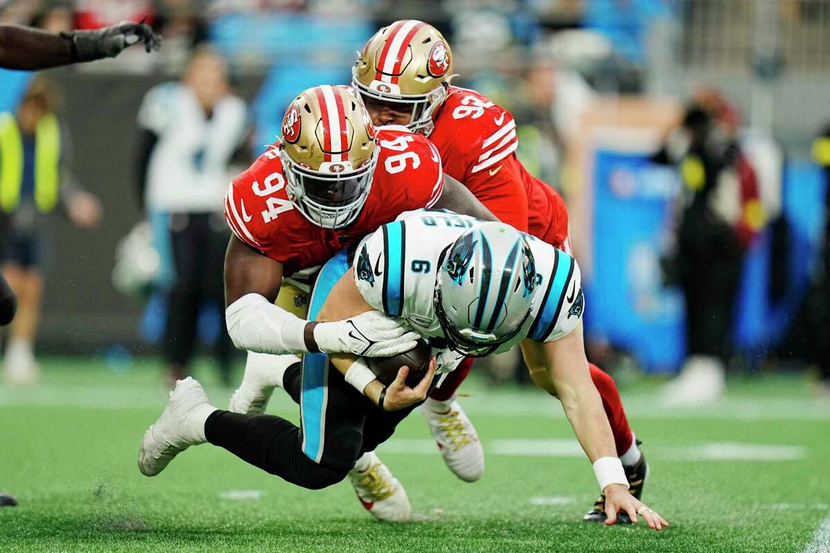 Carolina Panthers quarterback Baker Mayfield is sacked by 49ers defensive linemen Charles Omenihu (94) and Kerry Hyder.