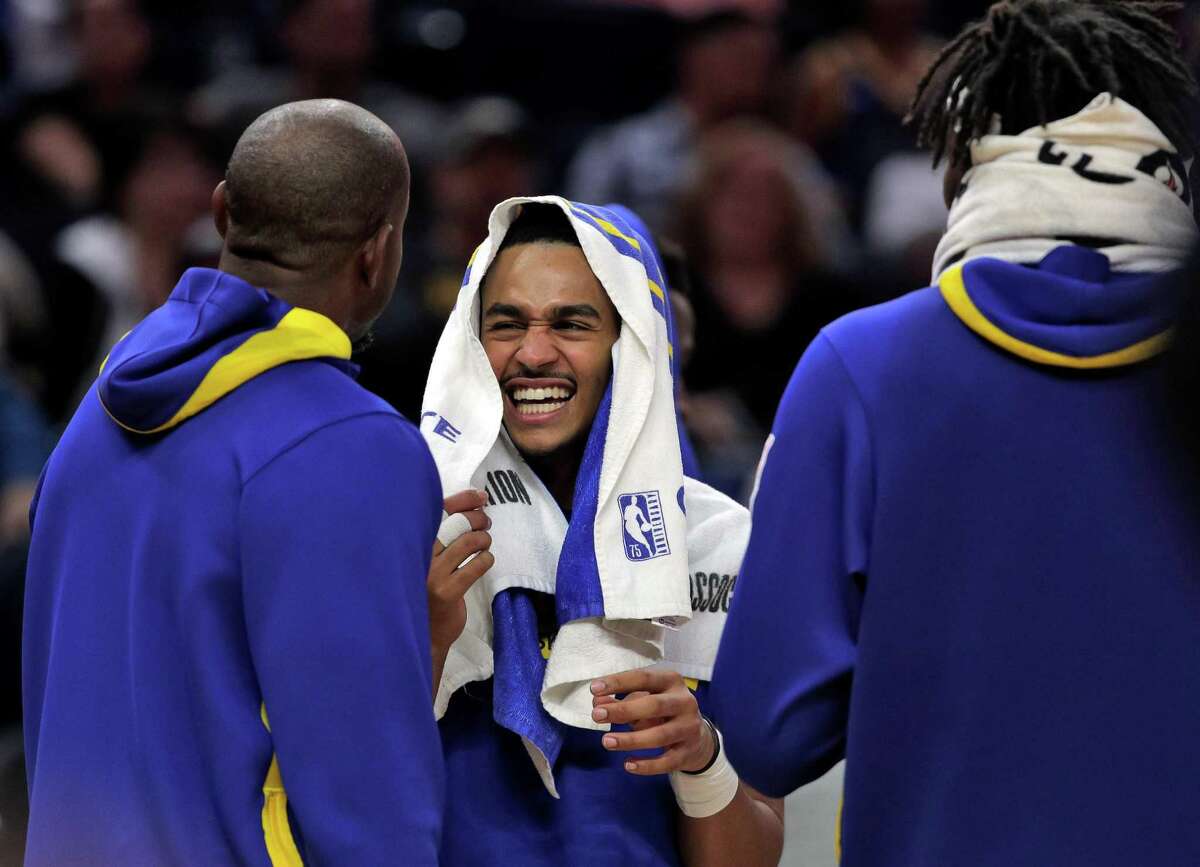 Jordan Poole (3) talks with teammates Andre Iguodala (9) left, and Kevon Looney (5) right, in the second half as the Golden State Warriors played the Los Angeles Lakers at Chase Center in San Francisco, Calif., on Sunday, October 09, 2022.