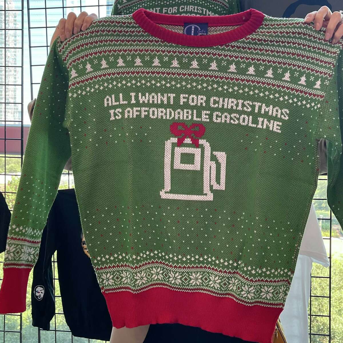 A knitted sweater reading "All I want for Christmas is affordable gasoline" sat among the merchandise being sold at Rep. Dan Crenshaw's third annual youth summit in downtown Houston. 