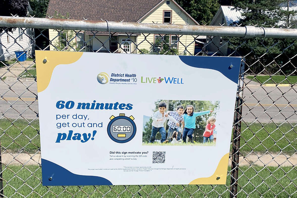 Signage on a fence in Maxwelltown encourages people to excercise for at least one hour day. The sigmage is part of a collaboration between the Live Well Manistee County coaltiion and the city of Manistee parks department. 