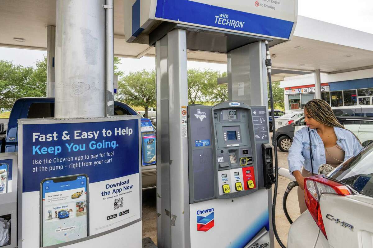 A customer prepares to pump gas at a Chevron station in Houston. Pump prices have jumped in the past week as demand has increased and oil prices have risen.