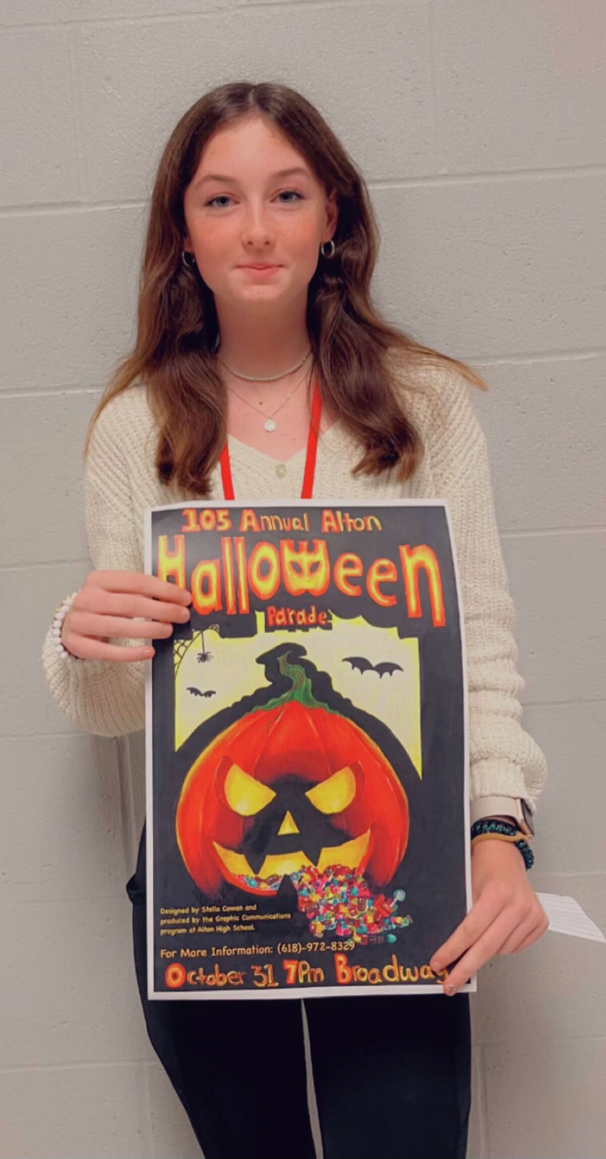 AHS freshman Stella Cowan holds her prize-winning Alton Halloween Parade poster design.