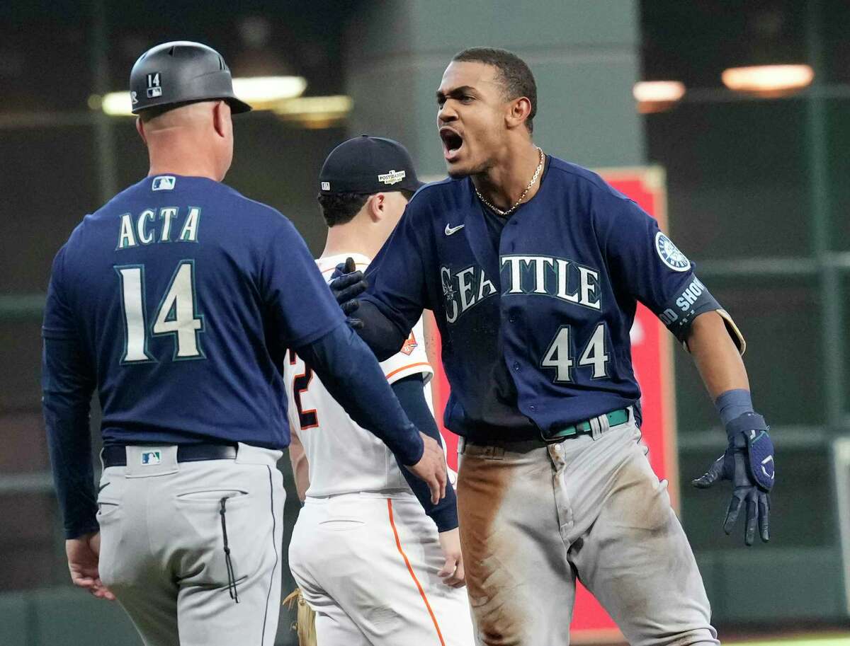 Mariners leadoff man Julio Rodriguez (44) was happy to see third-base coach Manny Acta after tripling off Justin Verlander in the fourth inning of Tuesday's ALDS opener against the Astros.  