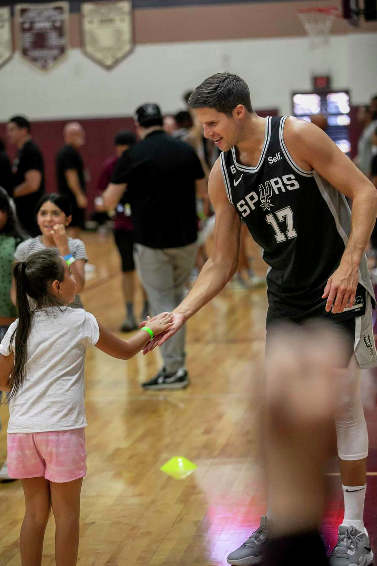 The Spurs’ Doug McDermott high fives a student during practice at Uvalde High School's Harvey Kinchlow Gym on Saturday.