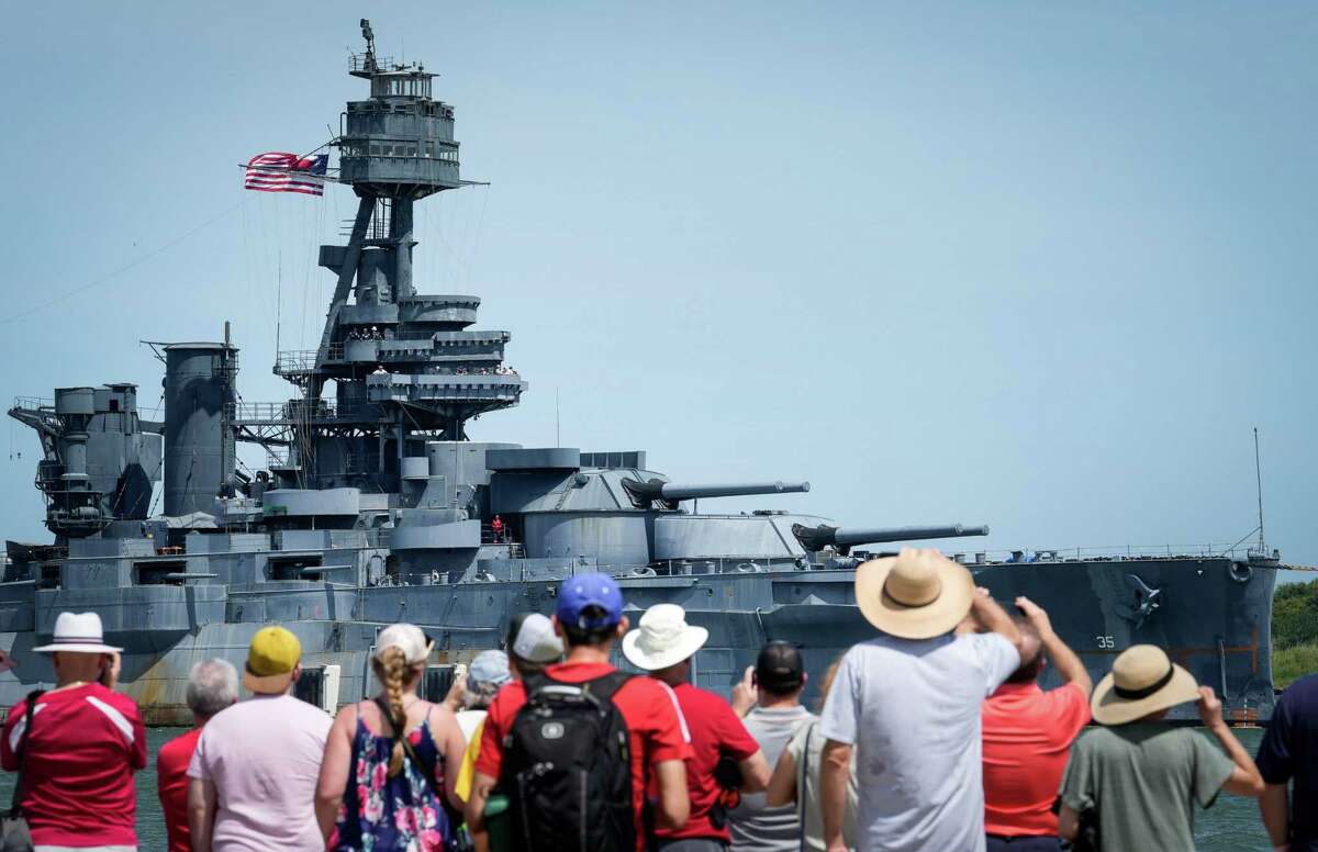 People watch as the Battleship Texas is towed past Seawolf Park as it arrives in Galveston for repairs Wednesday, Aug. 31, 2022, in Galveston.