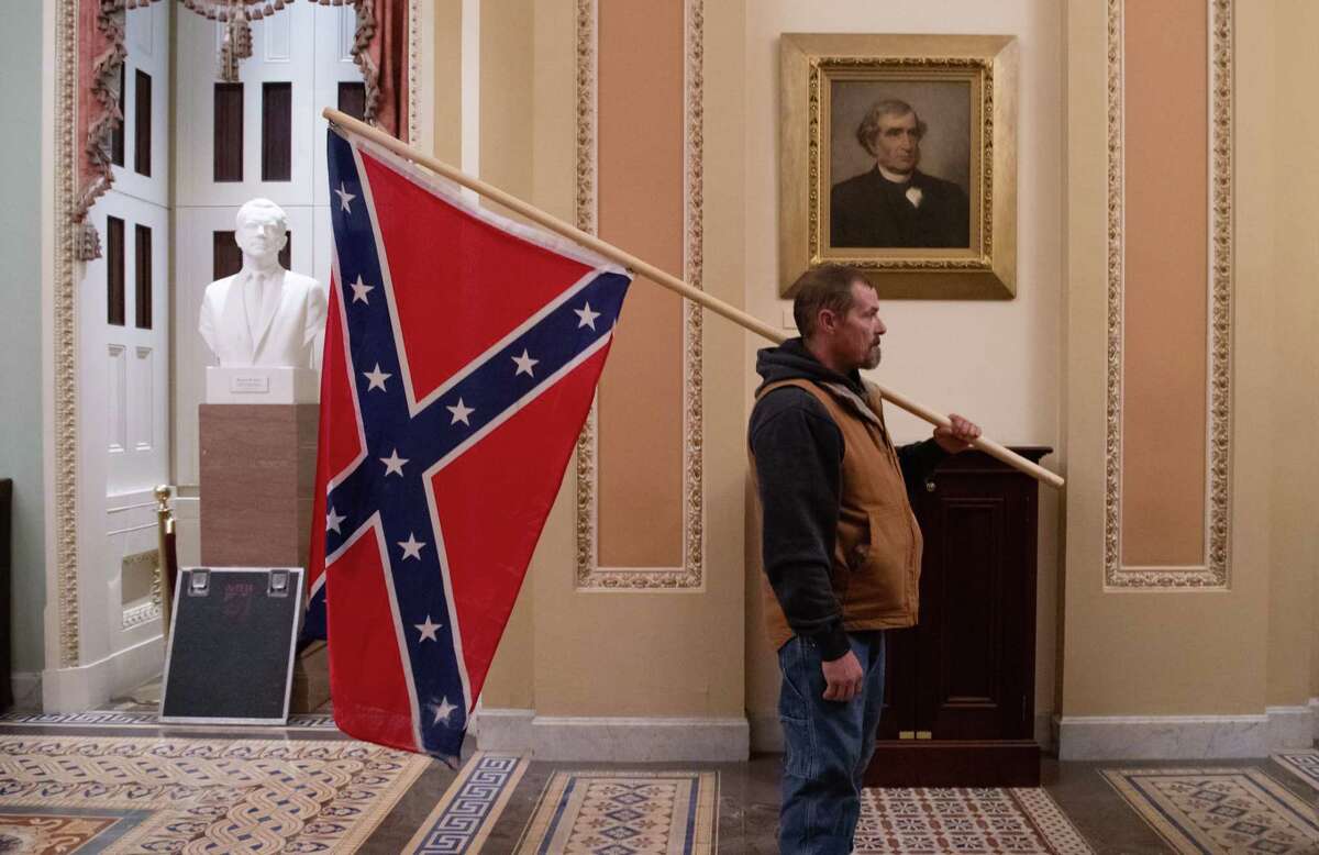 Kevin Seefried, a supporter of President Donald Trump, holds a Confederate flag outside the Senate Chamber during a riot in the U.S. Capitol in Washington, D.C., on January 6, 2021.