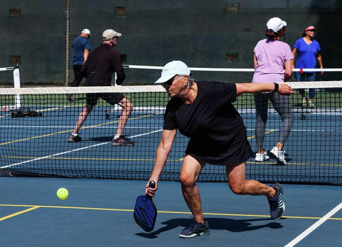 上个月，61岁的匹克球爱好者苏西·萨夫迪(右)在要塞墙球场打球。她是这项蓬勃发展的运动的众多忠实玩家之一，他们正在与市政厅争夺更多的球场空间。