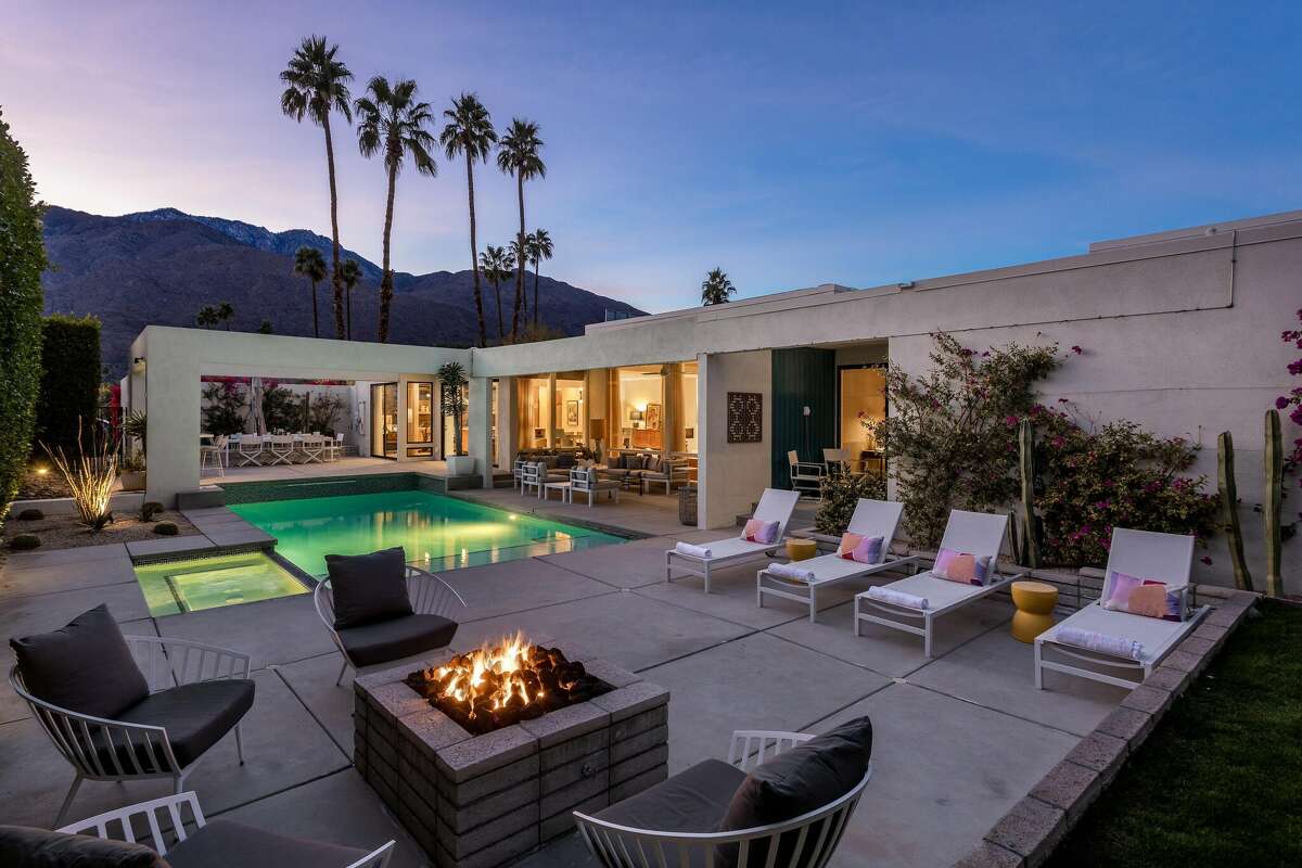 While the interior of the house is wonderful, guests renting XOXO Palm Springs will want to spend most of their time out back. The vacation rental has a lit pool and cozy fire pit among its amenities.