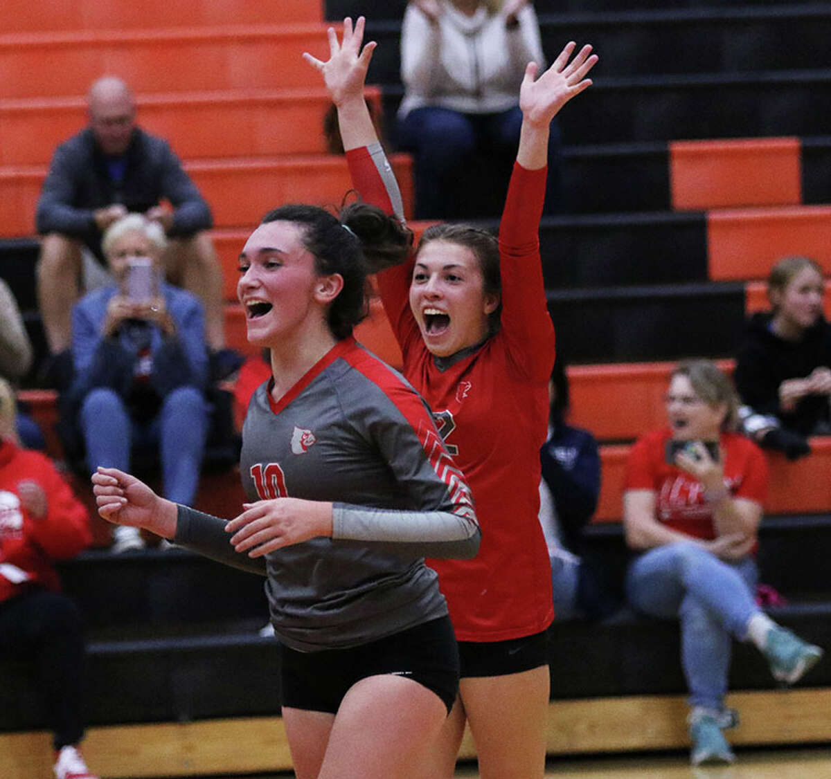 Alton's Kristina Castelli (left) and libero Payton Olney celebrate a Redbirds point against the Tigers in a SWC match Tuesday night at Edwardsville .