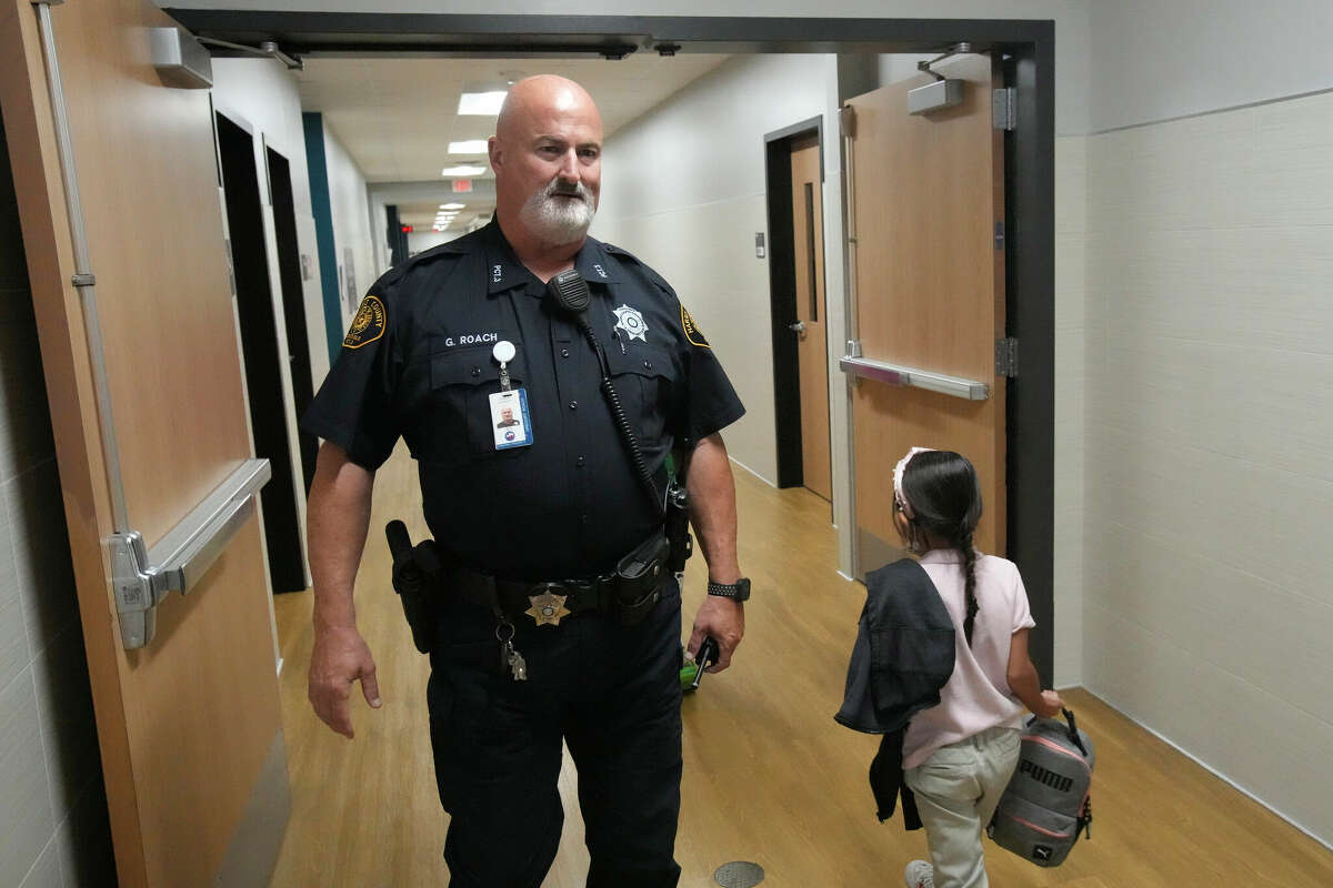 Harris County Pct. 3 deputy Greg Roach walks through the halls as he works at North Shore Elementary Wednesday, Oct. 12, 2022 in Houston. Handle with Care, a new program that the district is rolling out this school year that facilitates communication between police and schools to help student mental health. Authorities at crime scenes will contact the district any time they encounter a child at a crime scene, telling the school to "handle with care" that student, so teachers/counselors/staff will be on the look-out for signs of trauma or grief in that student. This is a national program being launched in Houston for the first time at Galena Park ISD
