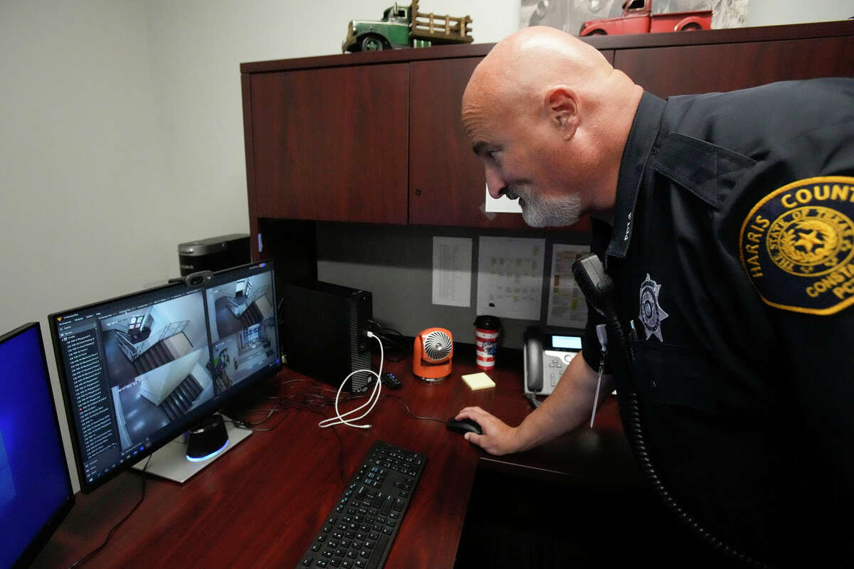 Harris County Pct. 3 deputy Greg Roach checks security cameras as he works at North Shore Elementary Wednesday, Oct. 12, 2022 in Houston. Handle with Care, a new program that the district is rolling out this school year that facilitates communication between police and schools to help student mental health. Authorities at crime scenes will contact the district any time they encounter a child at a crime scene, telling the school to "handle with care" that student, so teachers/counselors/staff will be on the look-out for signs of trauma or grief in that student. This is a national program being launched in Houston for the first time at Galena Park ISD