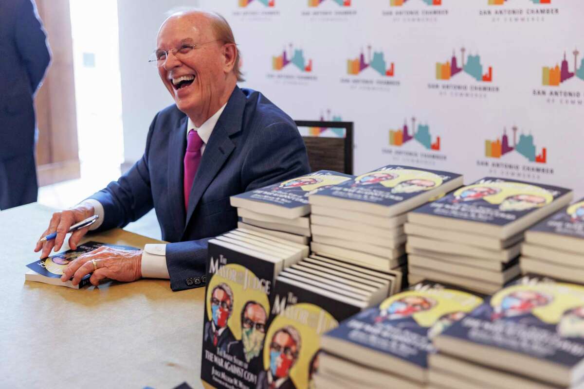 Bexar County Judge Nelson Wolff signs copies of his book “The Mayor and The Judge” following his final State of the County address at the Grand Hyatt in downtown San Antonio on Wednesday. He wrote the book in partnership with Major Ron Nirenburg about their experiences governing during the COVID-19 pandemic.