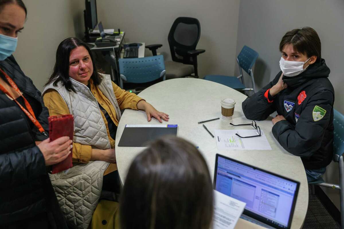 Nataliia Strohetska, 44 (second from left) and daughter Polina Strohetska (right), who are Ukranian refugees that arrived in the United States last week, sit in a appointment at the Human Services agency with translator Inessa Veselova (left) and employment specialist Hilary LaRowe (bottom) to obtain food stamps and other services in San Francisco.