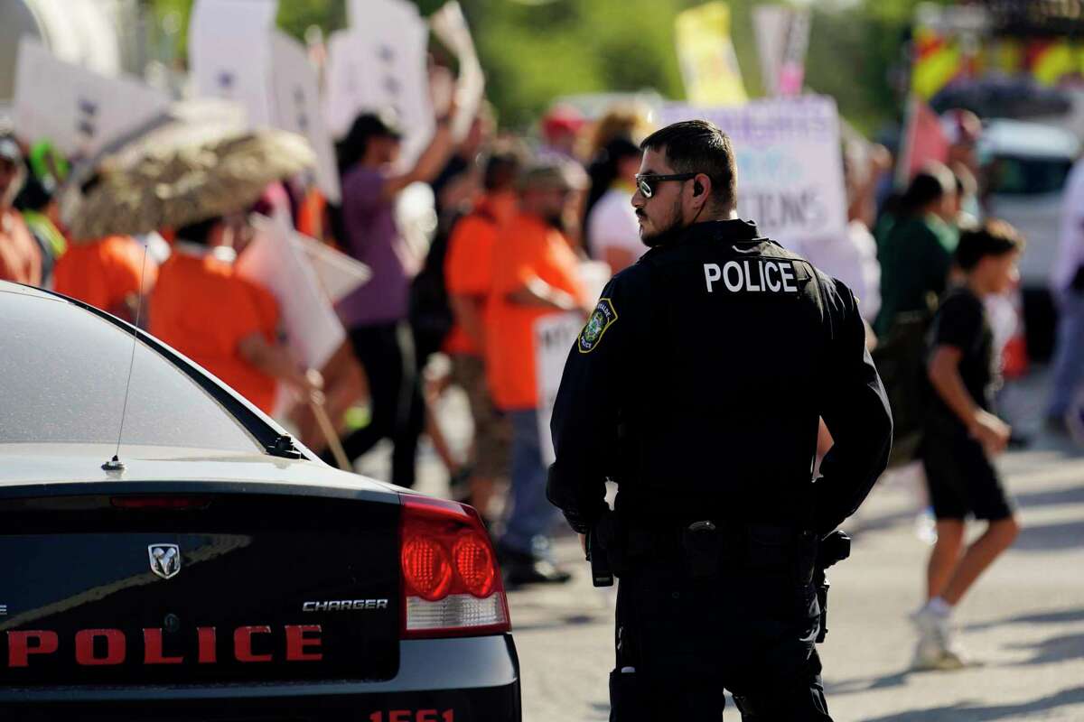 Un policía de Uvalde observa una marcha de familiares y amigos de los niños muertos en la Escuela Primaria Robb, el 10 de julio de 2022 en Uvalde, Texas.