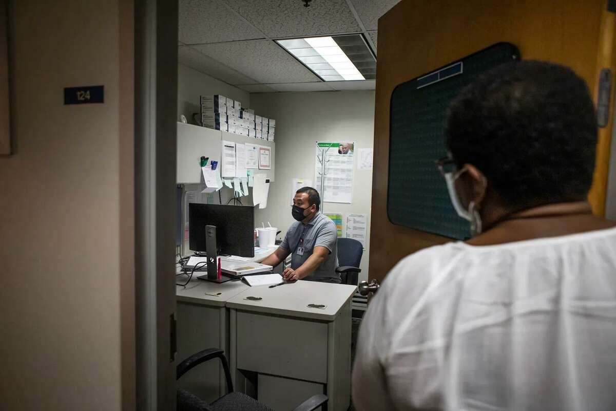 Fresno County communicable disease specialist Hou Vang works in his office as program manager Jena Adams checks in. They are trying to quell the spread of syphilis in the Central Valley.