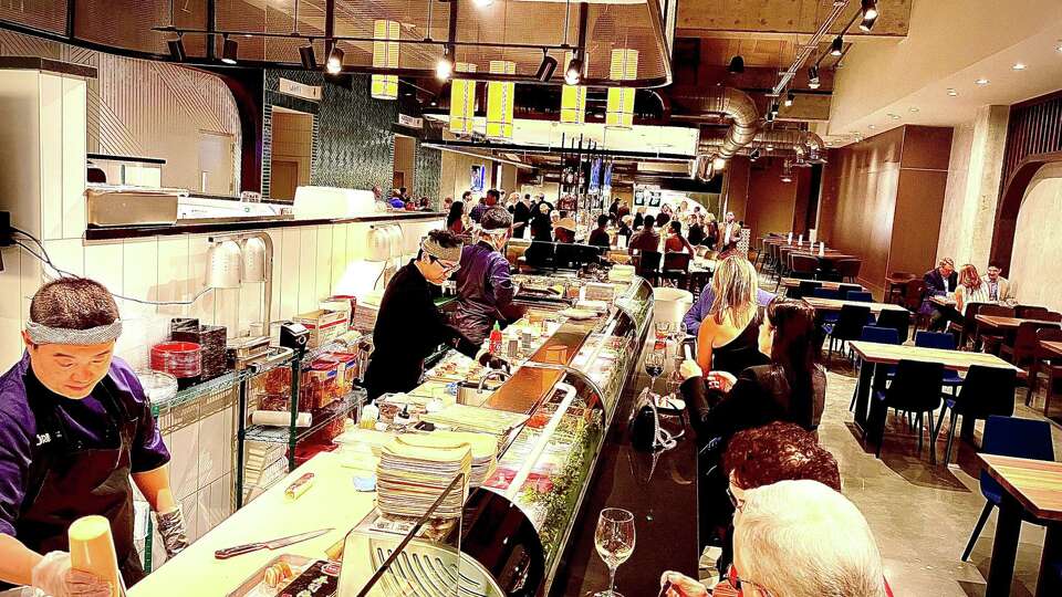 Guests dining at the Sushi Muse sushi bar at Lyric Market.