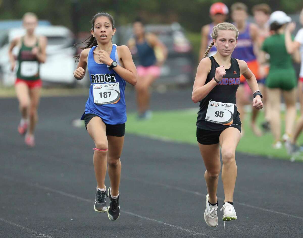 Grand Oaks’ McKenna Dunn, right, competes against Oak Ridge’s Daniela Ramirez during the District 13-6A cross country meet at College Park High School, Thursday, Oct. 13, 2022, in The Woodlands.