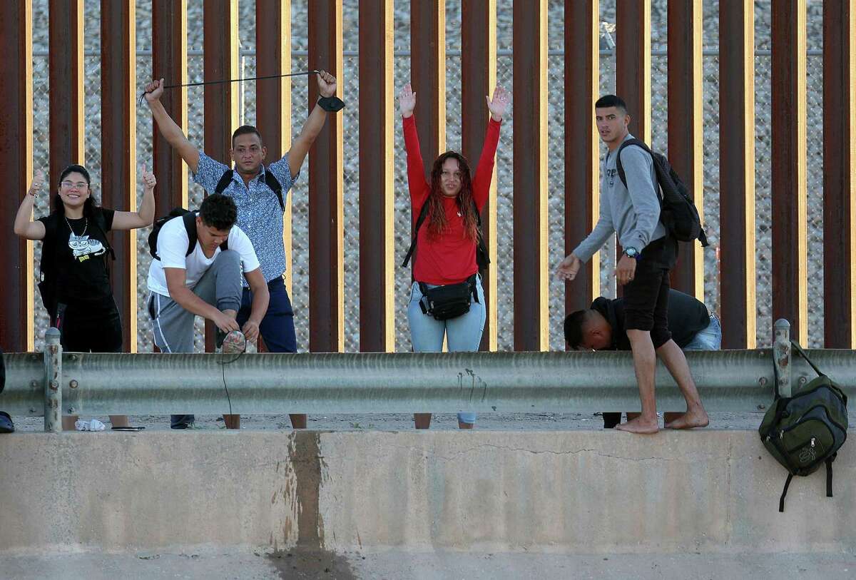 Venezuelan migrants gesture as they reach the U.S. border fence in El Paso to turn themselves into the U.S. Border Patrol after crossing the Rio Grande from Mexico on Sept. 22, 2022. According to federal government statistics, immigration agents encountered nearly 154,000 Venezuelans along the U.S.-Mexico border in the first 11 months of fiscal year 2022 — a 216 percent increase from the entire previous fiscal year. The majority of encounters with Venezuelans have occurred in the El Paso and Del Rio areas.