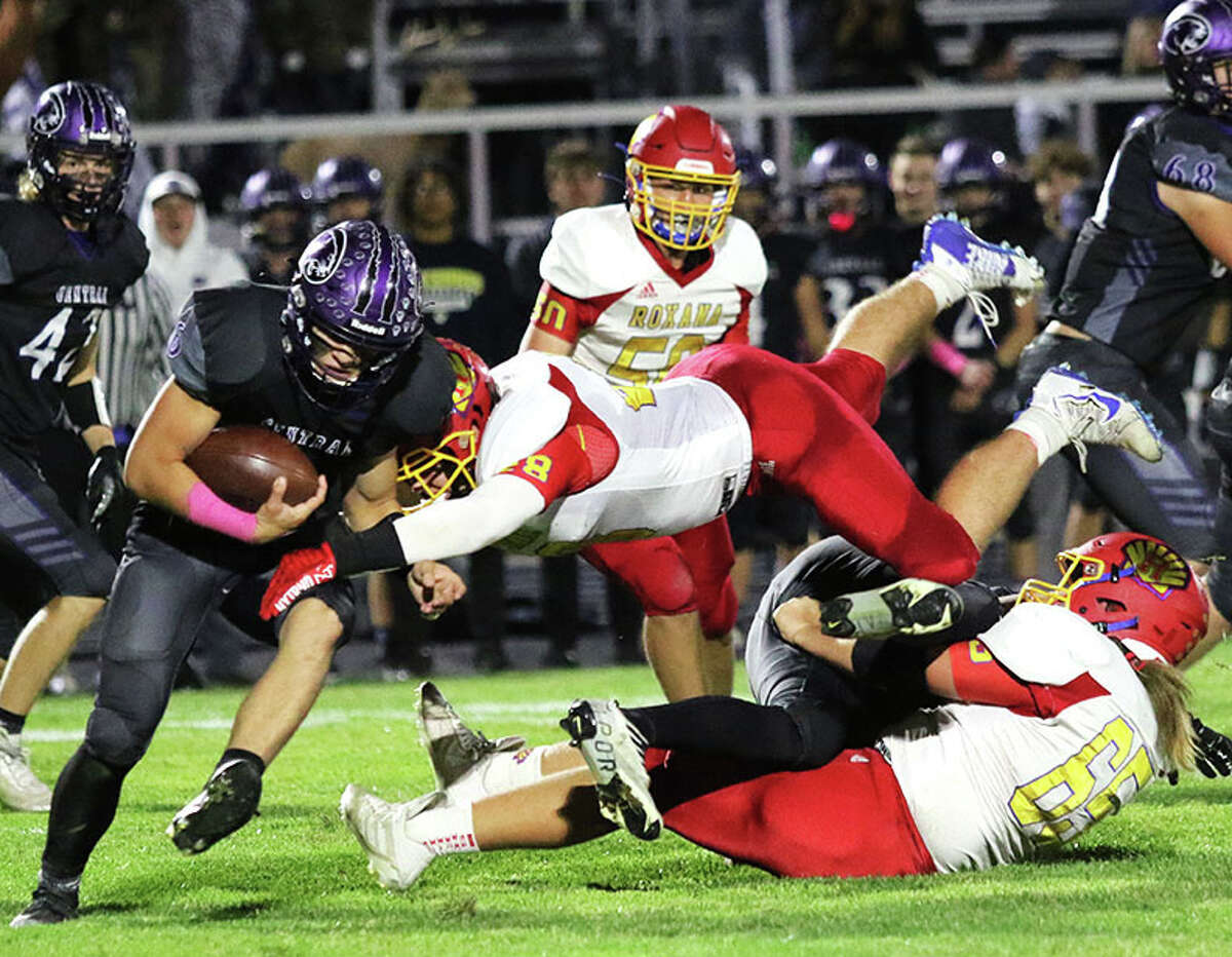 Roxana LB Jackson Harris leaps over teammate James Herring (65) to make the hit on Breese Central QB Conner Freeze in a Week 7 game at Breese.