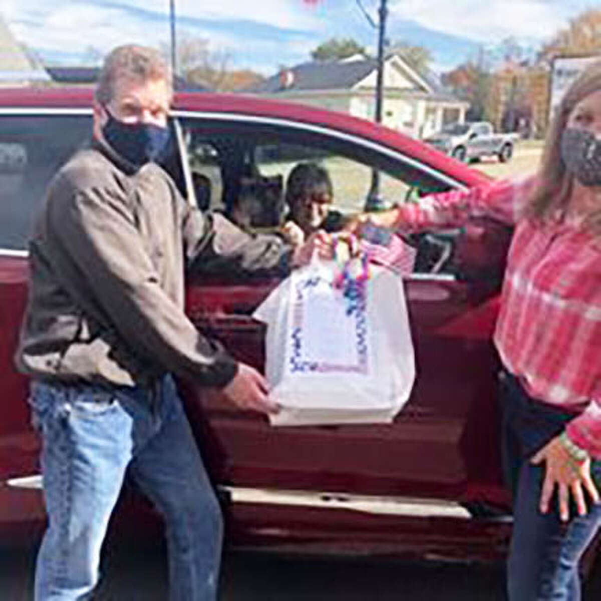 A volunteer from Main Street Community Center hands a meal to a family member of a veteran during curbside pickup at a previous Veterans Luncheon at MSCC. This year’s lunch is Nov. 2 and on-site dining is sold out, but reservations are still available for delivery and curbside pickup.
