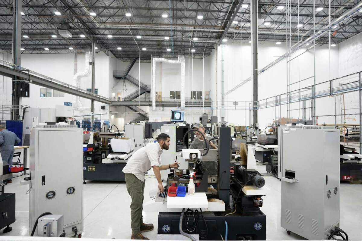 Employees work at Noveon Magnetics Inc.’s processing facility in San Marcos. The company recycles rare earth minerals from used electronics to produce magnets used in many high-tech products.