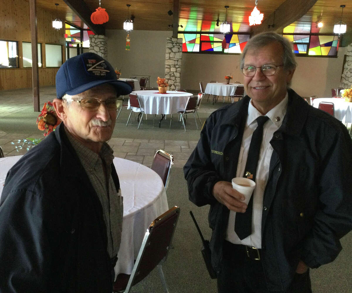Retired firefighter David Dittmar and Stronach Township firefighter Randy Stoykovich exchange stories at the Manistee senior center on Monday during the First Responder Appreciation Day event.